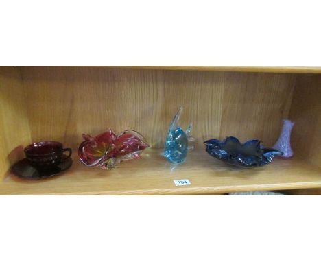 A shelf of coloured glass ware.