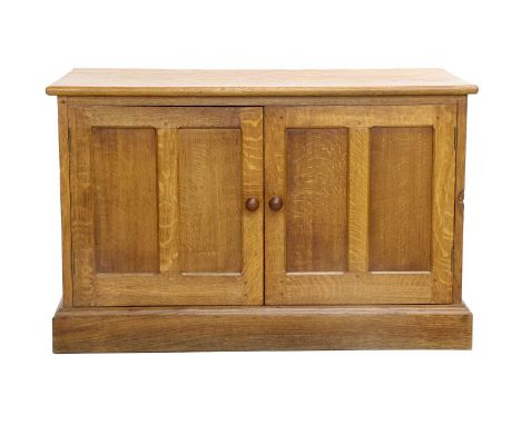 Workshop of Robert Mouseman Thompson (Kilburn): An English Oak Panelled Cupboard, adzed top, above two cupboard doors, turned