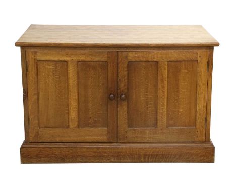 Workshop of Robert Mouseman Thompson (Kilburn): An English Oak Panelled Cupboard, adzed top, above two cupboard doors, turned