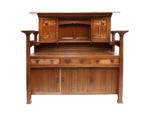 An Arts &amp; Crafts Scottish School Oak Dresser, overhanging two plank top, above two specimen wood inlaid cupboard doors, e
