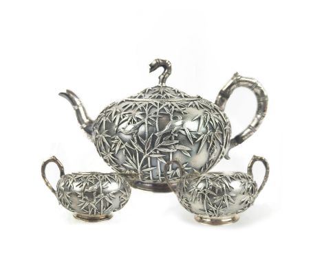 CHINESE EXPORT SILVER THREE PIECE TEASET, by Wang Hing, comprising teapot, sugar bowl and milk jug, decorated with bamboo and