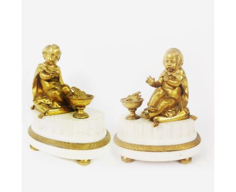 A PAIR OF GILT BRONZE AND MARBLE CLOCK GARNITURES, in the form on putti on a plinth, 22cm high.