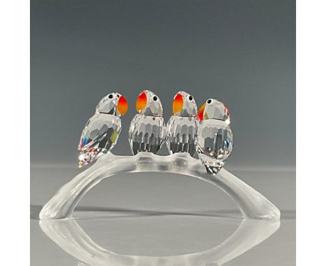 Lead crystal four baby lovebirds sitting on a branch that were part of the Feathered Beauties collection. They sit on a three