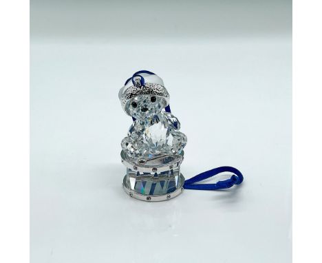 Brilliant faceted cut crystal figure of Kris Bear sitting on a drum, hat is frosted. Part of the Kris Bears collection. This 