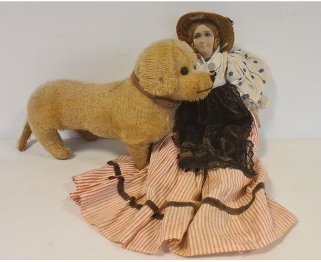 Early 20th century dachshund soft toy and a doll with fabric painted face, straw hat, spotted blouse, striped skirt, velvet p