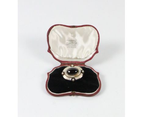 A gold set Brooch, of oval format with blue ground and gilt enamel borders design, inset with four pearls and central ruby ty