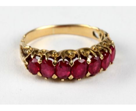 An attractive gold Ladies Ring, inset with seven ruby type graduating stones. (1)Provenance: Purchased from Louis Wine, Dubli