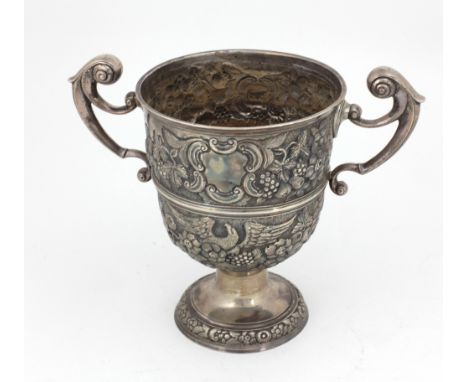 An 18th Century Irish silver two handled Cup, with repoussé decoration depicting eagles, fruit, flowers, etc shield shaped en