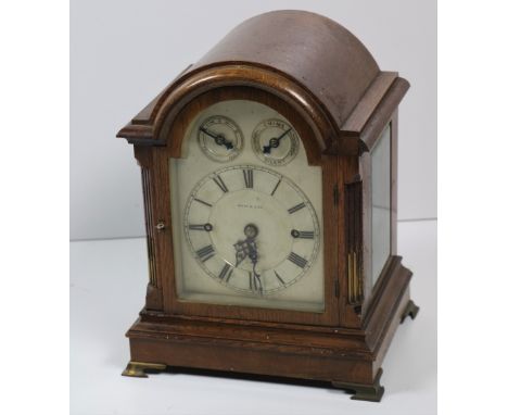 An attractive dome shaped oak framed Bracket Clock, the arched silvered dial with Roman numerals by West &amp; Son, flanked b