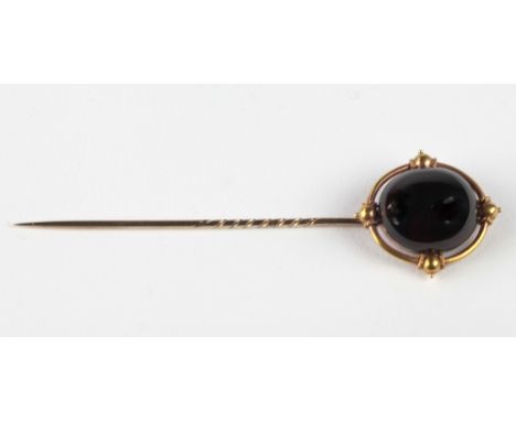 An attractive gold Tie Pin, with oval ruby type stone decorated in Celtic taste, by John D. Harris, Goldsmith, Queen Square, 