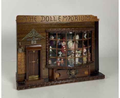 A fine quality Diorama entitled "The Doll Emporium," the facade with domed front window and side door with step, and decorati