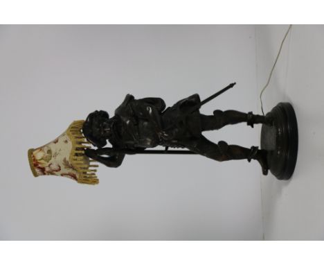 An attractive brass figured Table Lamp, modelled as Don Quixote in typical military attire, on circular base. (1)