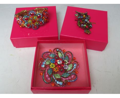 A COLLECTION OF THREE BUTLER AND WILSON JEWELLERY ITEMS, comprising a cuff bangle, a large circular floral theme brooch, appr
