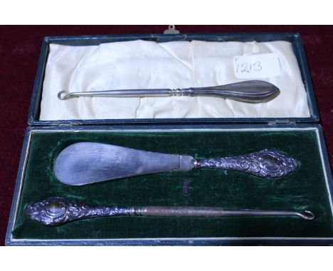 A antique cased hallmarked silver handled button hook &amp; shoe horn set. And one other silver handled button hook. 