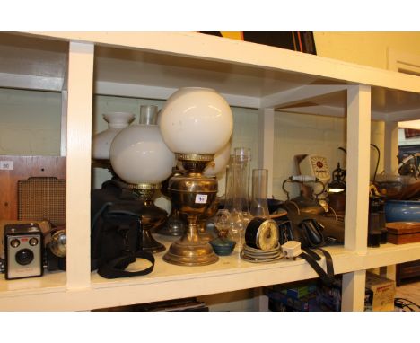 Full shelf of oil lamps, metalwares, cycle parts, walking canes, musical instruments and parts, etc.