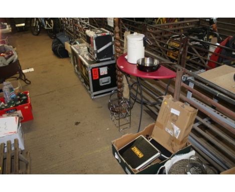 A wooden topped metal side table; a standard lamp lacking shade; a camp bed; small wine rack; saucepan; small bin; bike rack 