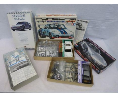 Three boxed model kits, all depicting different models of Porsche. 