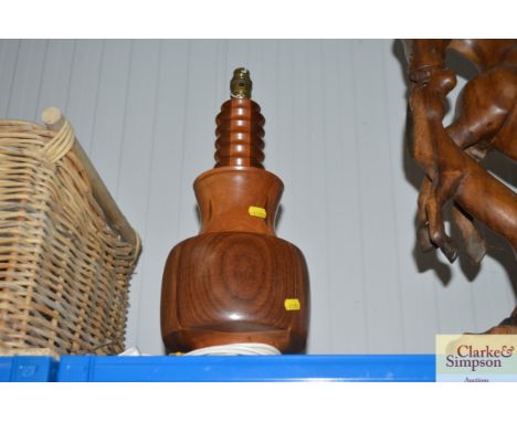 A turned wooden lamp base lacking shade