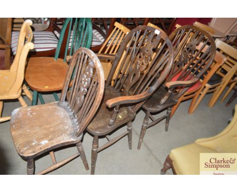 A pair of stick and wheel back carver chairs together with one other stick and wheel back