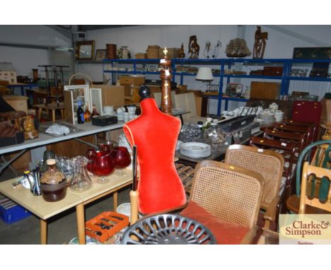 A tailors mannequin together with a turned standard lamp lacking shade