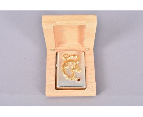 A 2014 Limited Edition Dragon Zippo lighter, the brushed chrome case with applied yellow metal dragon, with red paste set sto