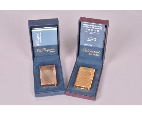 Two S.T Dupont lighters, both gold plated with engine turned design, with serials 2400DM and X8AHO2, both with fitted retaine