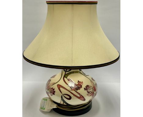 A Moorcroft compressed ovoid table lamp, tube lined with orchids and scrolling fronds, in shades of pink and purple on a whit