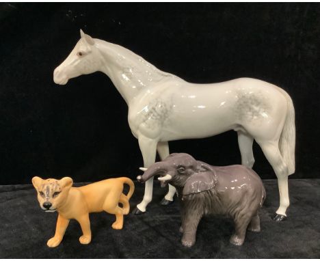 A Beswick model of an Elephant, trunk raised; a Beswick model of a Lion Cub; a Beswick model of a dappled grey Horse (3) 