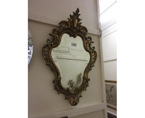 19th Century gilt brass cartouche wall mirror with a bevelled plate together with a brass table lamp