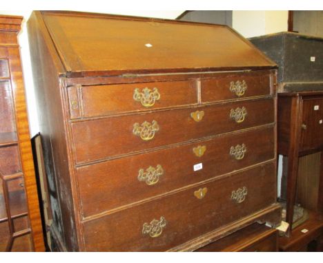 Small 18th Century oak bureau with a fall front above two short and three long graduated drawers with brass handles and escut