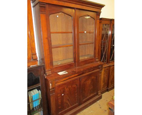 19th Century mahogany bookcase having moulded top above two glazed doors, enclosing adjustable shelves over a single moulded 