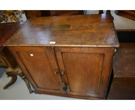 George III oak campaign cabinet with two panel doors enclosing drawers and shelves, inset with a brass plaque inscribed, ' Th