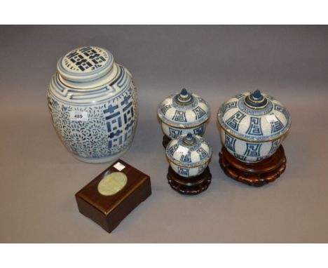 20th Century blue and white ginger jar and cover, on hardwood stand, a graduated set of three oriental blue and white pots wi