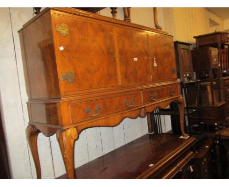 20th Century walnut side cabinet having three flush panel doors enclosing various shelves and drawers above two short drawers