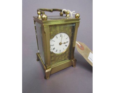 Miniature brass cased carriage clock with circular enamel dial and Roman numerals