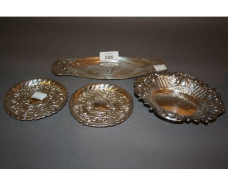 Pair of circular embossed silver trinket dishes, similar oval trinket dish and an Art Nouveau oval silver trinket dish