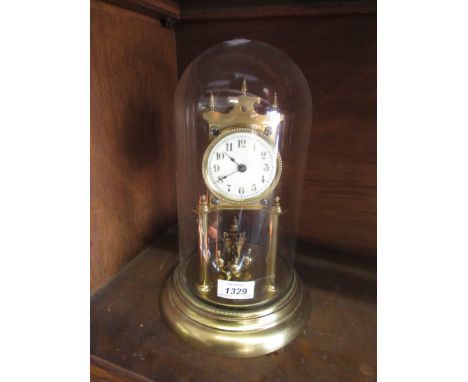 Brass three hundred day clock with enamel dial and Arabic numerals beneath a glass display dome