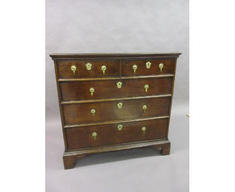 Early 18th Century oak chest of two short and three long drawers with brass drop handles and escutcheons raised on bracket fe