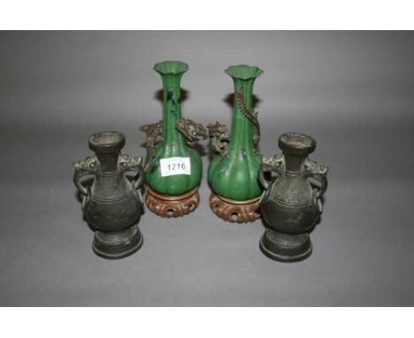 Pair of Japanese green patinated spelter vases applied with bronzed figures of dragons, each on a hardwood stand together wit
