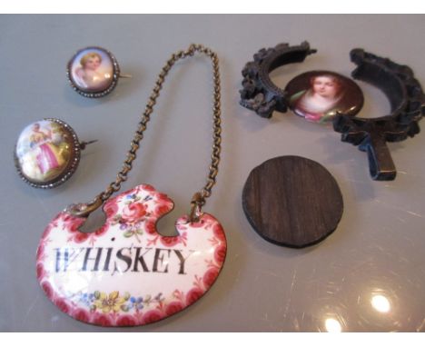 Two small 19th Century enamelled mother of pearl and cut steel brooches, an enamel whisky label and a miniature porcelain pla