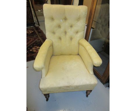 Victorian button upholstered library armchair covered in yellow damask and raised on low turned tapering supports with brass 