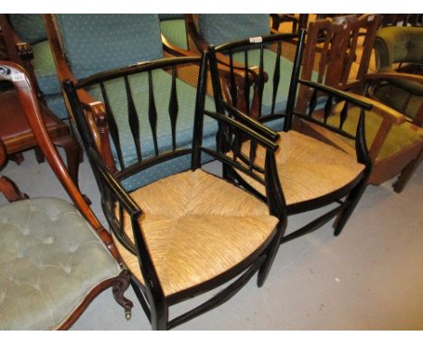 Pair of Arts and Crafts ebonised ladder back open armchairs with rush seats