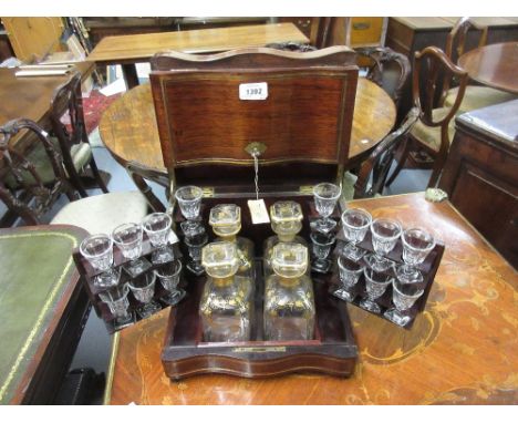 Victorian mahogany and brass inlaid decanter box of serpentine form, the double hinged lid with a brass plaque, the interior 