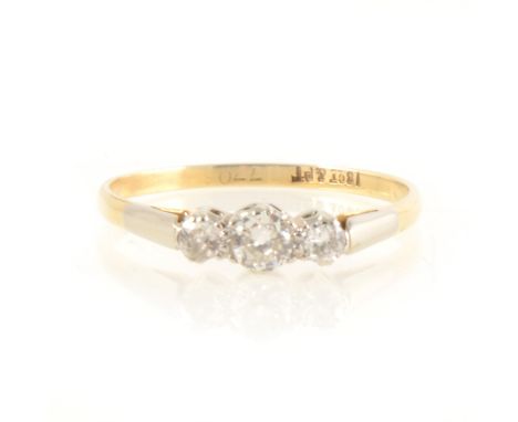 A diamond three stone ring, the old cut diamonds, graduated in size claw set in a yellow and white metal traditional mount ma