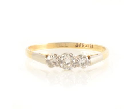 A diamond three stone ring, the old cut diamonds, graduated in size claw set in a yellow and white metal traditional mount ma