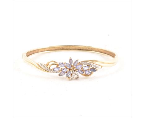 A half hinged bangle set with tanzanite and diamonds, the 9 carat yellow and white gold bangle claw set with thirteen marquis