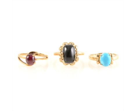 A ruby ring, a star diopside ring, and a turquoise ring, all cabochon cut stones in 9 carat yellow gold, ring sizes N to N1/2