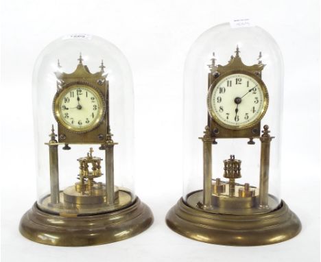 Brass torsion clock, the 2.25" cream dial over a disc pendulum, upon a stepped turned circular base and under a glass dome, 1