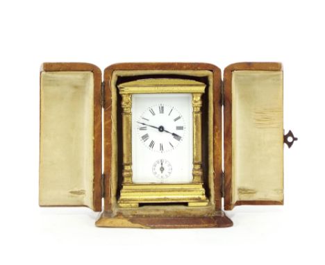 Miniature French carriage clock with alarm, within a pillared rounded arched stepped brass case, 3" high, with a fitted foldi