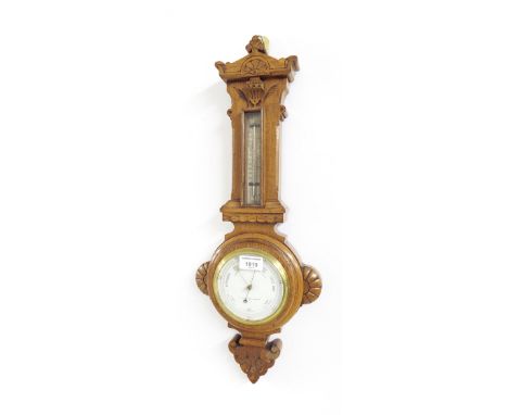 Small English oak barometer/thermometer, the 4.5" cream dial signed Lilley & Son, London, within a foliate carved case, 24" h
